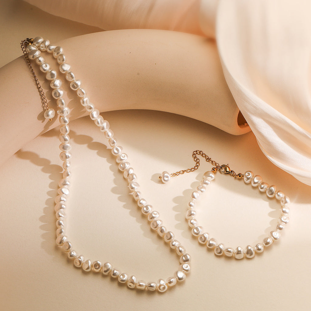 Pearl necklace and earrings on a soft fabric background